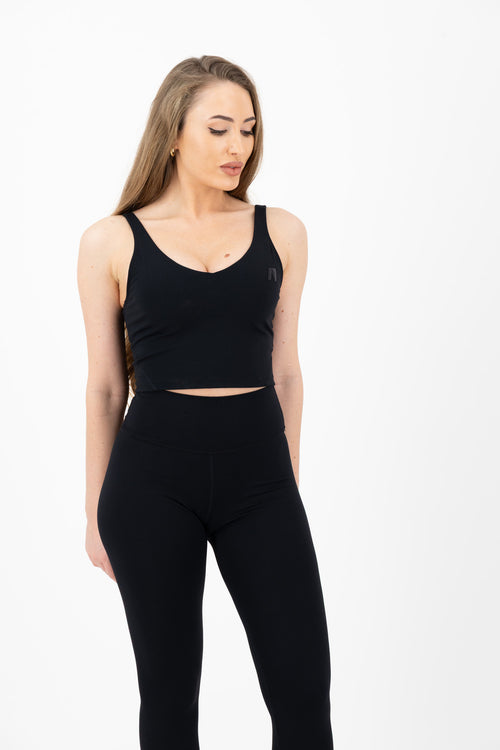 Woman wearing a black athletic outfit on a white background