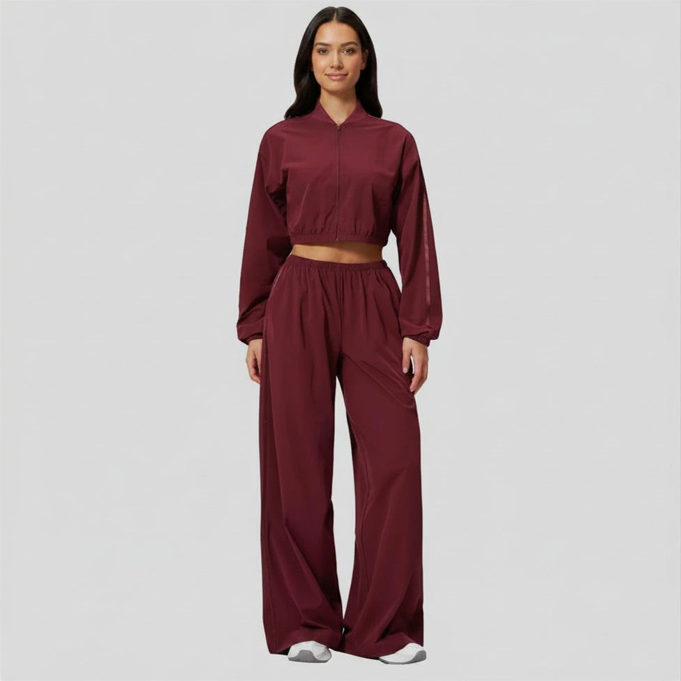 Woman wearing a burgundy tracksuit on a plain background