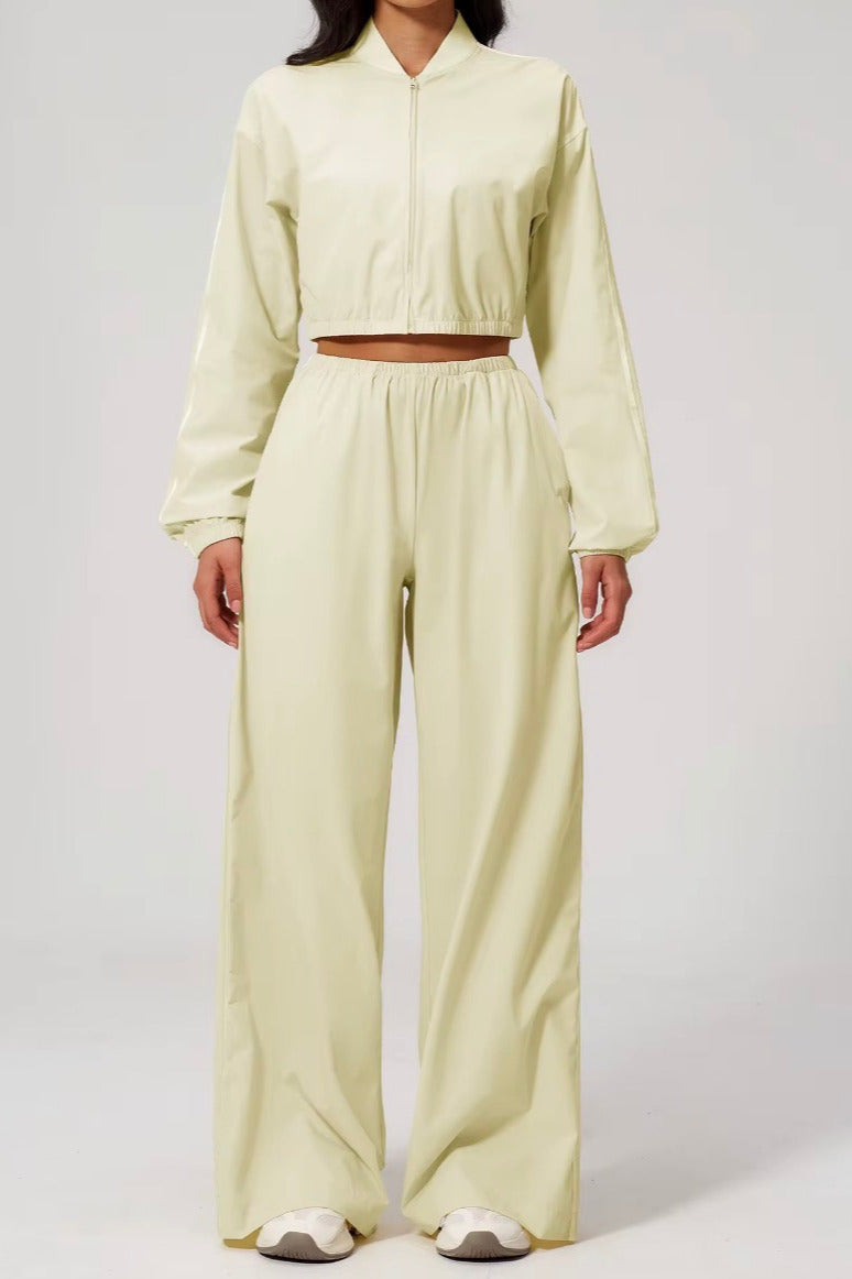 Person wearing a light yellow outfit with a matching top and wide-leg pants on a white background